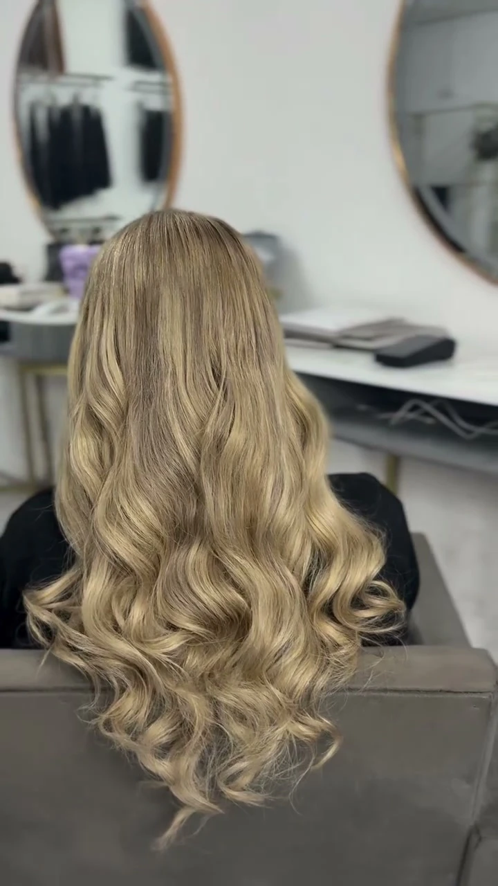 The same Royal Hair Malta client with a longer blonde curled hairstyle after the transformation